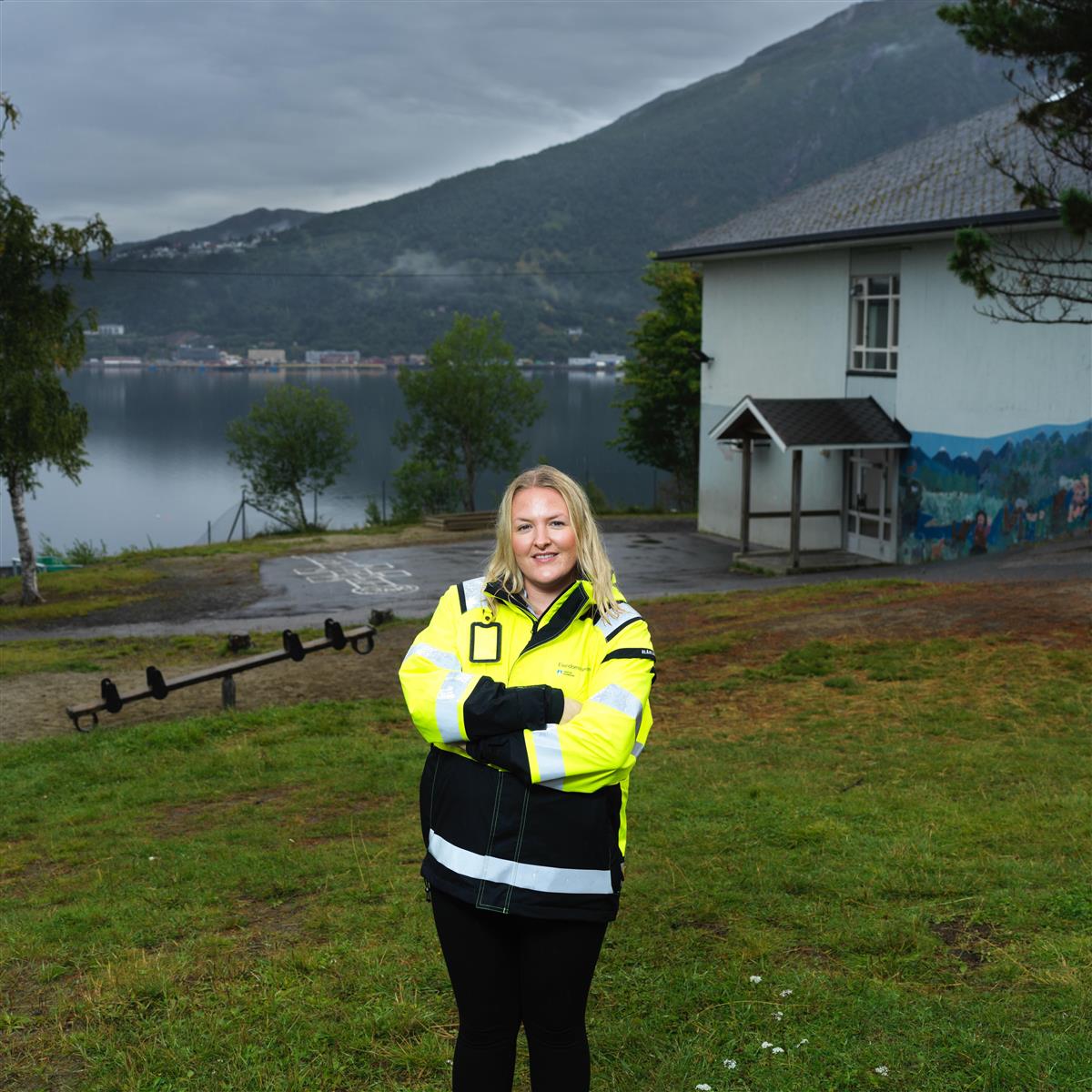 Portrett av Ingrid Lyngedal Rydholt. Bildet er tatt på en lekeplass utenfor Ankenes skole, med Narvik i bakgrunnen. - Klikk for stort bilde