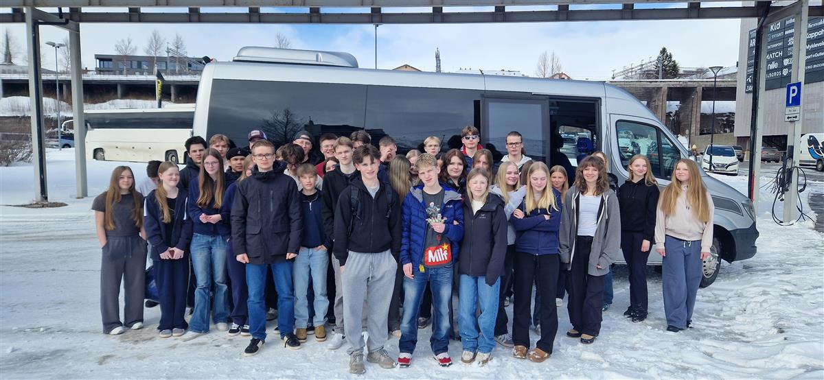 En gruppe ungdommer foran en minibuss. - Klikk for stort bilde