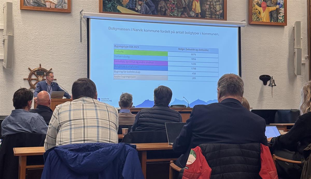 Bilde informasjonsmøte i kommunestyresalen på rådhuset i Narvik. På bildet ser man ryggen til tilhørere, mens assisterende rådmann Lars Skjønnas står på talerstolen. - Klikk for stort bilde